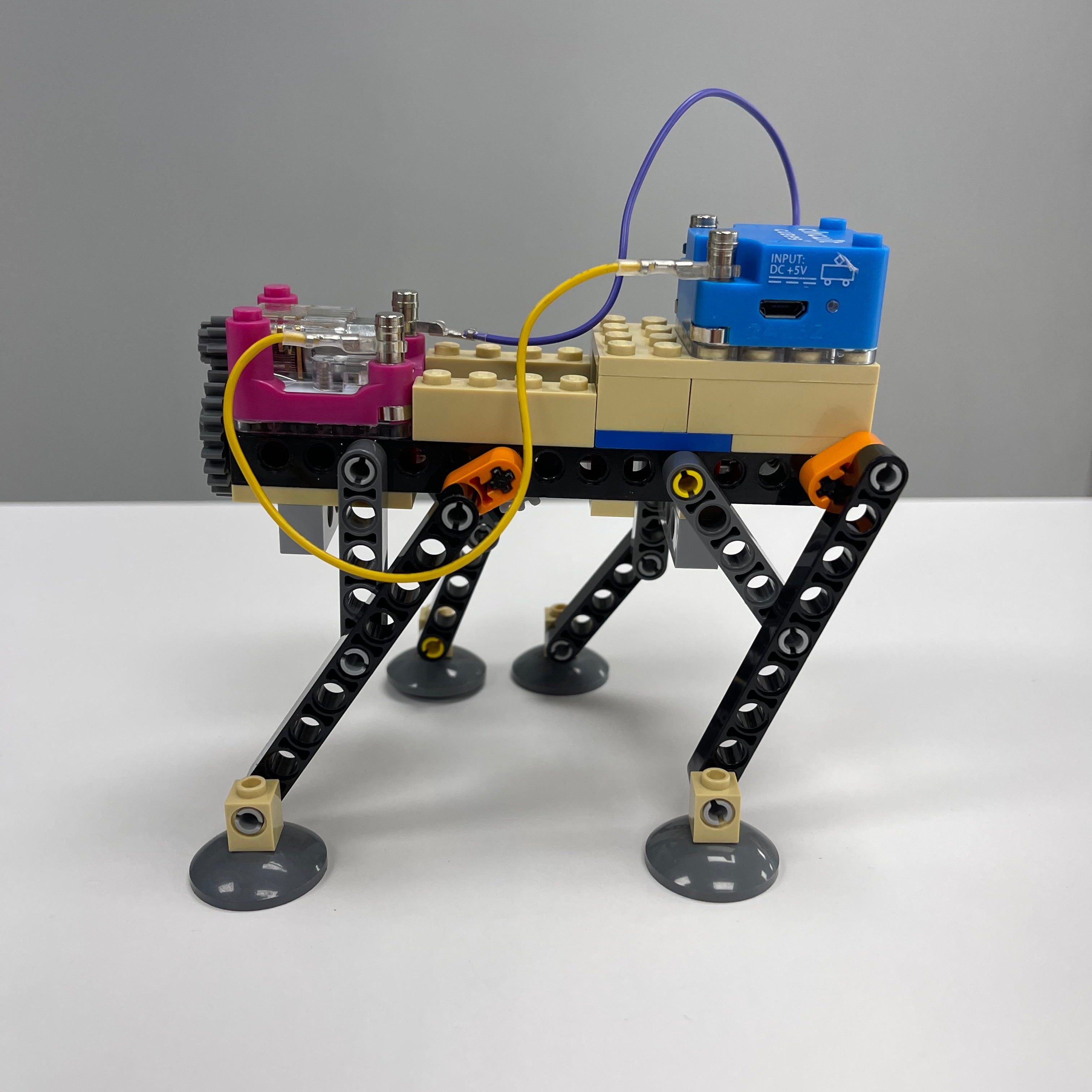 Mechanical arm model with colorful components on a gray and white background